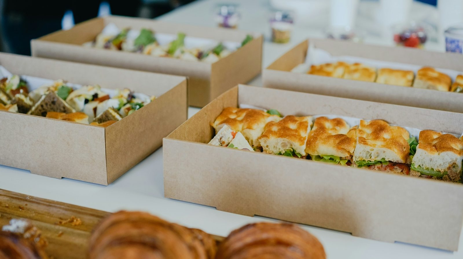 Boxed sandwiches and pastries ready for an office lunch