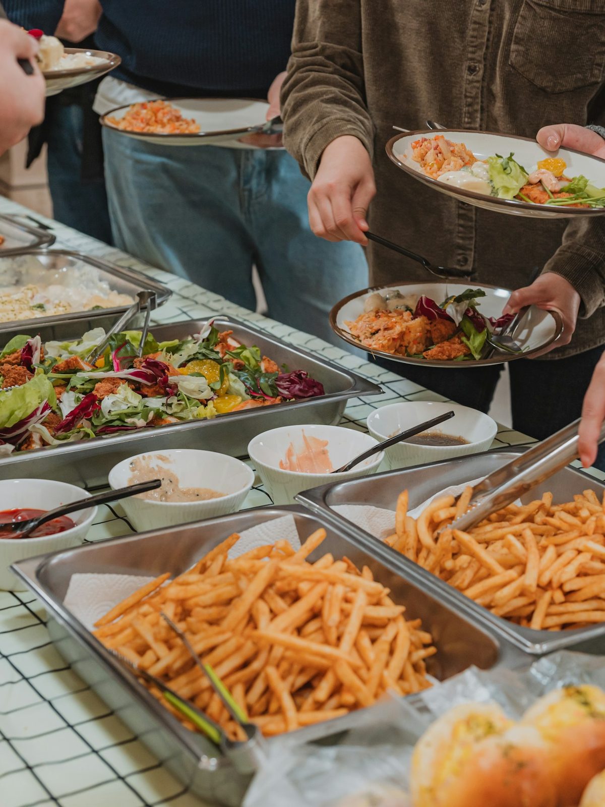 Coworkers serving themselves from a catered lunch buffet